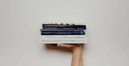En hånd som holder noen bøker